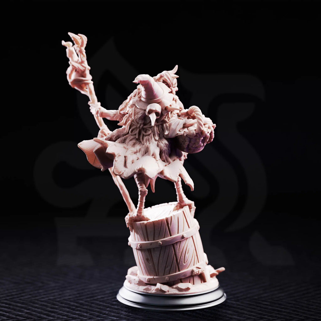 Rear view of Baba Yaga Ancient Witch by DM Stash, showing the fantasy witch miniature with staff, fur cloak, baskets, barrel base, ropes, and sculpted back details.