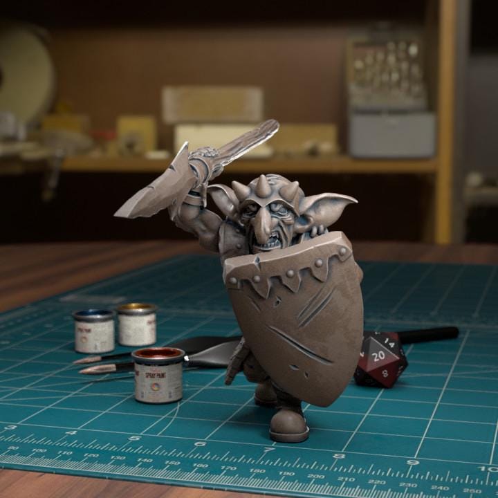 Resin 3D‑printed goblin raider miniature by TytanTroll holding a spear overhead and a large shield. 
