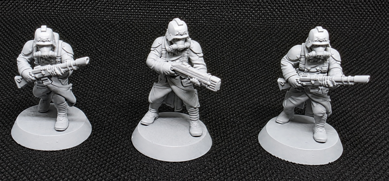 Three pre-assembled GrimGuard riflemen in unique firing poses against a black background.