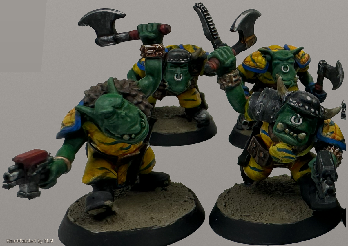 Hand-painted Guttertech Orc Raiders with green skin, yellow armor, axes, pistols, and horned helmets.