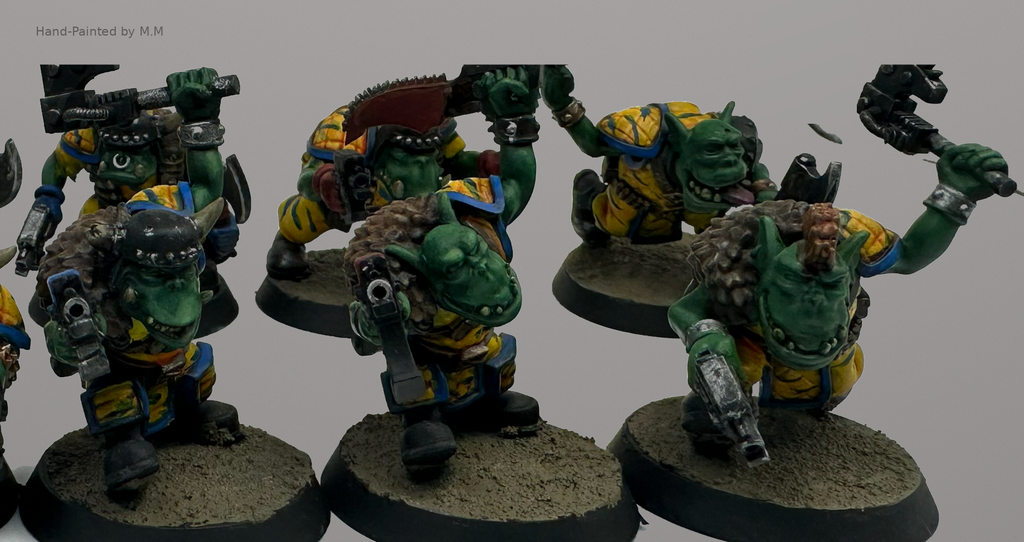 Hand-painted Guttertech Orc Raiders with green skin, yellow armor, axes, pistols, and horned helmets.