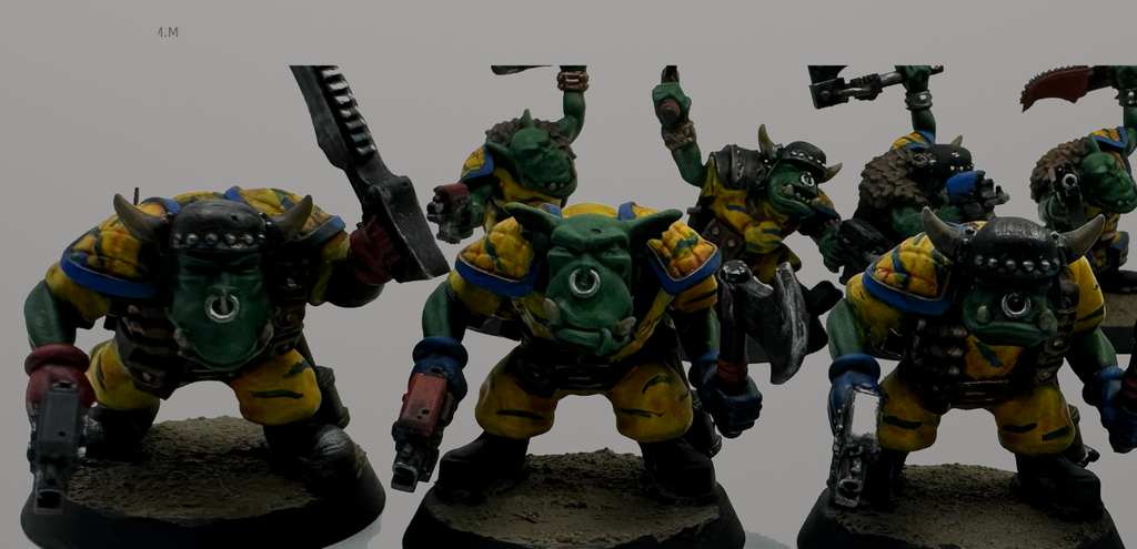 Close-up of hand-painted Guttertech Orc Raiders in yellow and blue armor with metal weapons and textured bases.