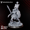 Legio Artemis Shield Maiden by DakkaDakka, a 32mm resin female warrior miniature with shield, raised blade, banner, cape, and scenic ritual base.