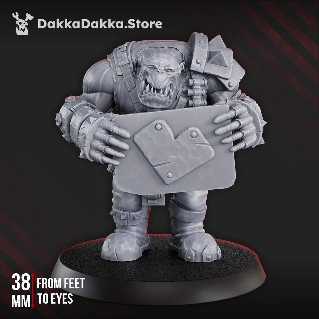 Make WAAAGH! not War by DakkaDakka, a sci-fi orc resin miniature holding a large sign shield with armor, ammo straps, and chunky battlefield gear.