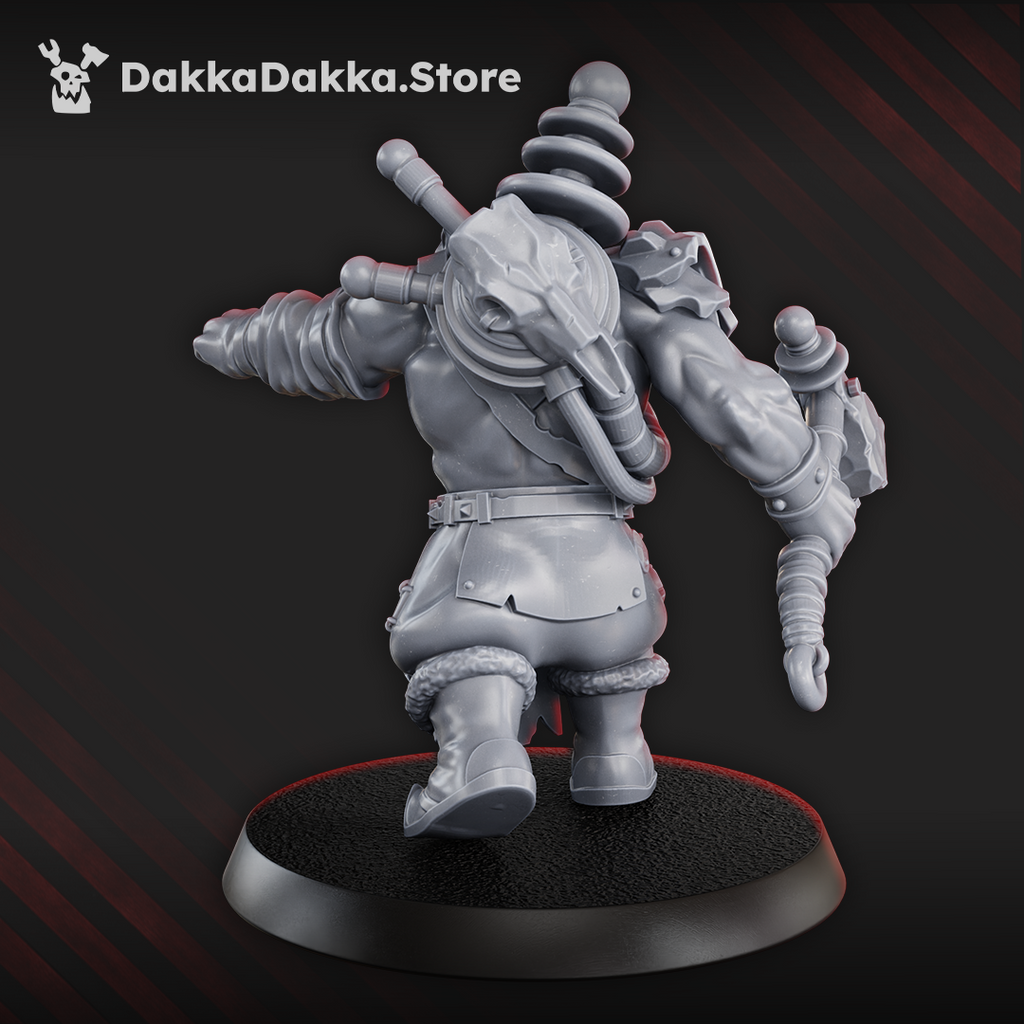 Rear view of the Tech Boy showing his back-mounted power unit, electrical coils, cables, armored shoulder plate, hammer, and fur-trimmed clothing.
