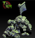 Guttertech Scrap Engineer & Helper by Trollet Miniatures, showing a sci-fi orc mechanic with heavy scrap-tech gear, banner, claw arm, and small goblin helper carrying tools.