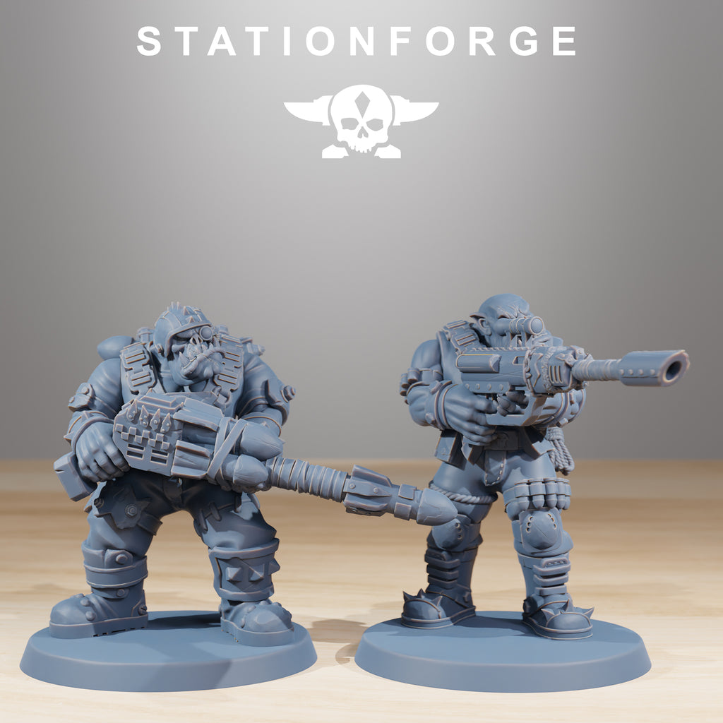 Two Orkaz Skillers miniatures by Station Forge featuring heavy armor, large weapons, masks, and rugged sci-fi tabletop detail.