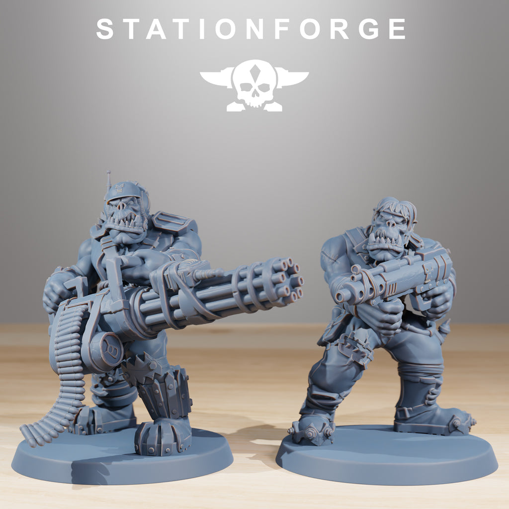 Two Orkaz Skillers miniatures by Station Forge with oversized ranged weapons, including a rotary-style heavy gun and compact blaster.