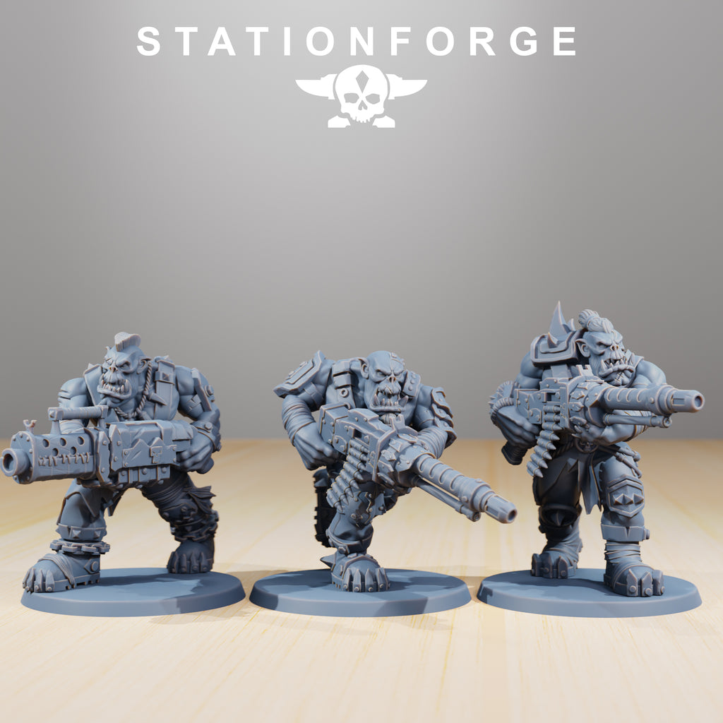 Three Orkaz Strappaz heavy weapon miniatures by Station Forge, shown with oversized sci-fi firearms and bulky armored poses.