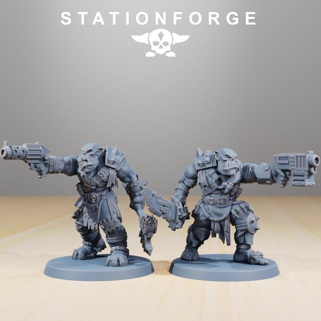 Two Orkaz Strappaz miniatures by Station Forge with large guns and melee weapons, featuring rugged armor and aggressive greenskin detail.